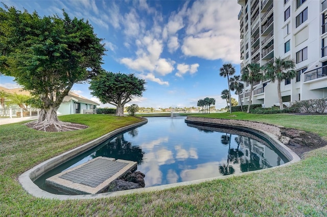 view of pool featuring a water view and a yard