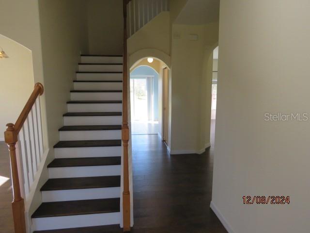 staircase featuring hardwood / wood-style floors and a towering ceiling