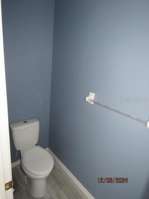 bathroom featuring wood-type flooring and toilet