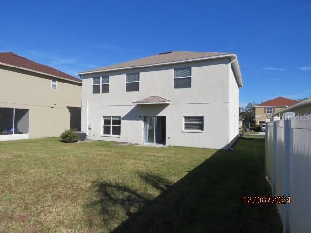 back of house featuring a yard