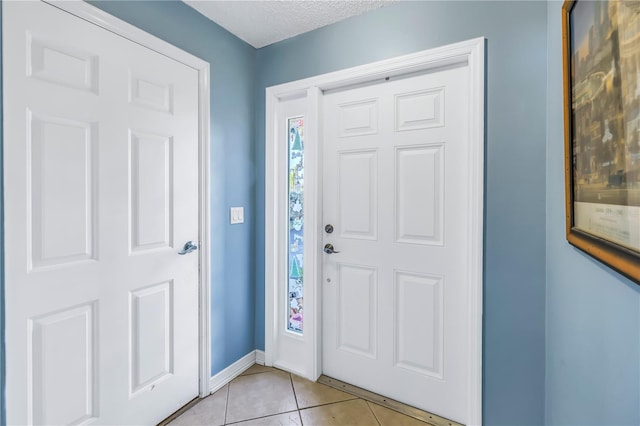 foyer with a textured ceiling and light tile patterned flooring