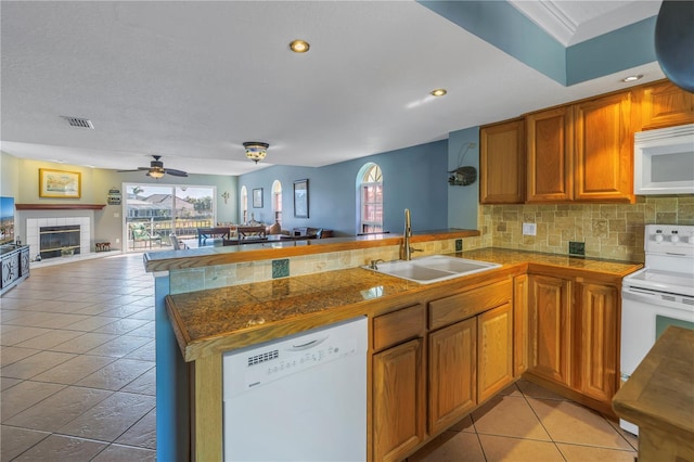 kitchen featuring kitchen peninsula, white appliances, and sink