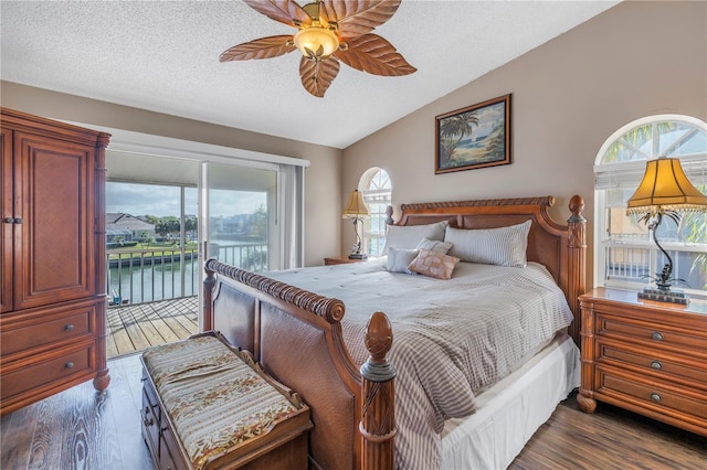 bedroom with dark hardwood / wood-style flooring, a water view, access to outside, and multiple windows