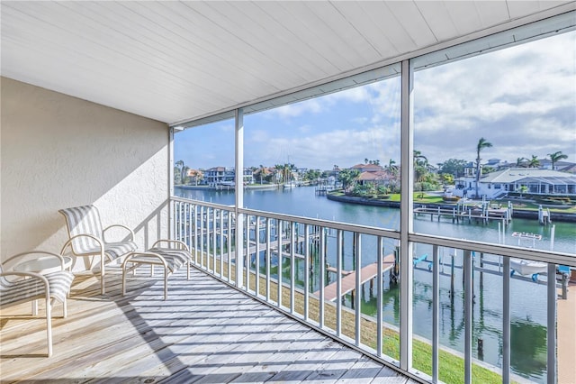 sunroom featuring a water view