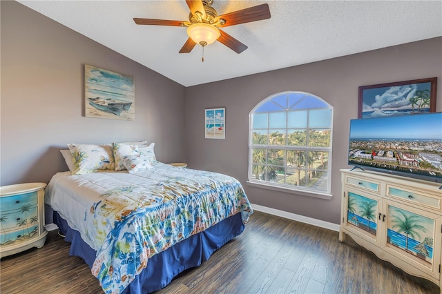 bedroom with a textured ceiling, ceiling fan, vaulted ceiling, and dark hardwood / wood-style floors