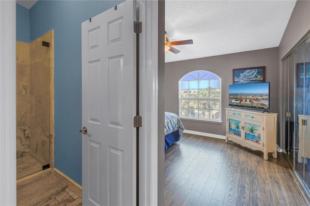 interior space with ceiling fan, dark hardwood / wood-style flooring, and a textured ceiling