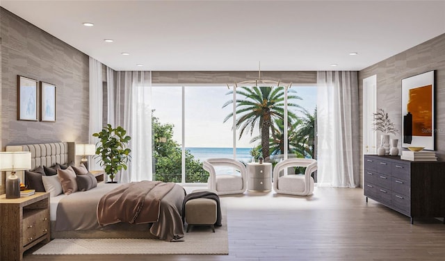 bedroom with multiple windows, hardwood / wood-style floors, and a water view