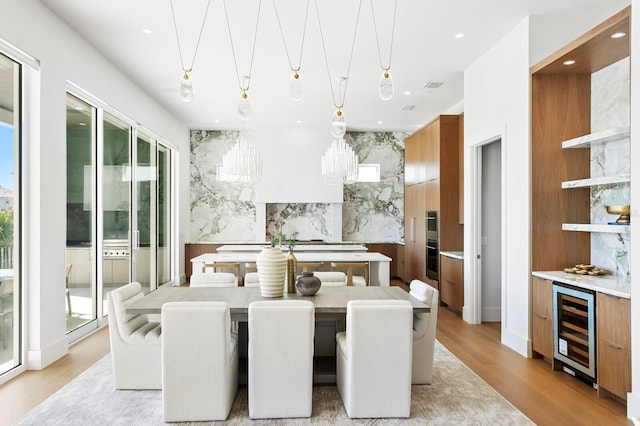 dining space featuring wine cooler and light hardwood / wood-style floors