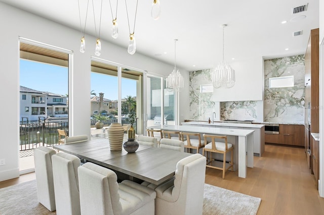 dining room featuring light hardwood / wood-style floors and a water view