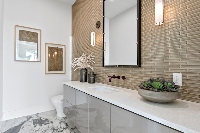 bathroom with vanity, backsplash, and toilet