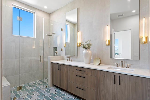 bathroom with tasteful backsplash, vanity, an enclosed shower, and tile walls