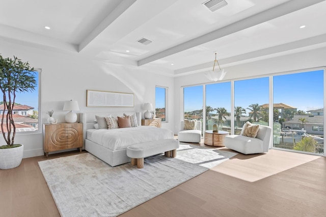 bedroom featuring beamed ceiling, access to outside, and light wood-type flooring