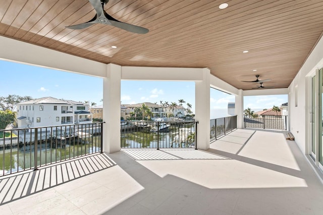 view of patio / terrace with a balcony, ceiling fan, and a water view