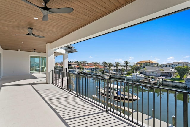 balcony featuring a water view and ceiling fan