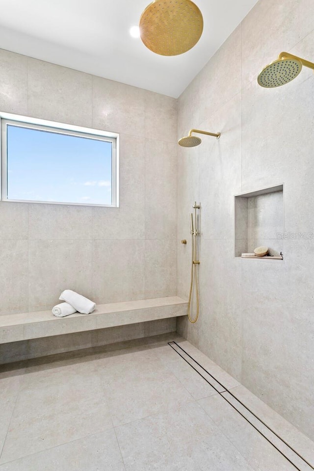 bathroom with tiled shower and tile patterned floors