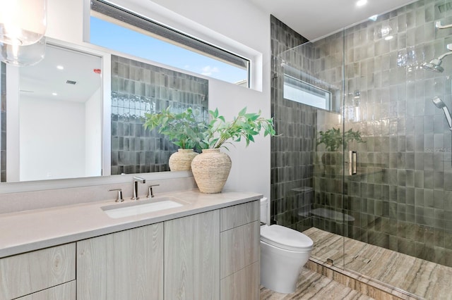 bathroom featuring vanity, toilet, and walk in shower