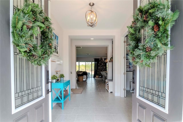 entrance foyer with light tile patterned floors and a chandelier