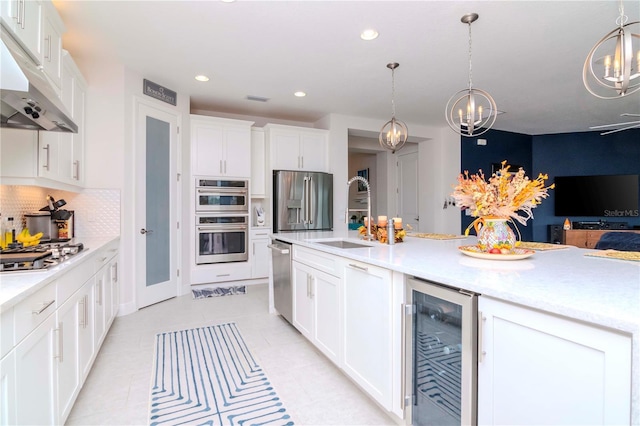 kitchen with pendant lighting, sink, appliances with stainless steel finishes, white cabinets, and beverage cooler