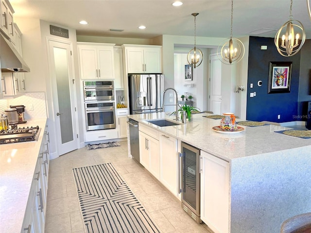 kitchen featuring a spacious island, backsplash, beverage cooler, appliances with stainless steel finishes, and a sink