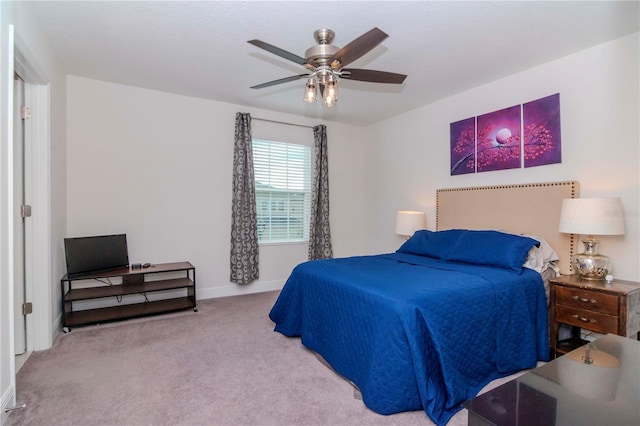 carpeted bedroom with a ceiling fan and baseboards