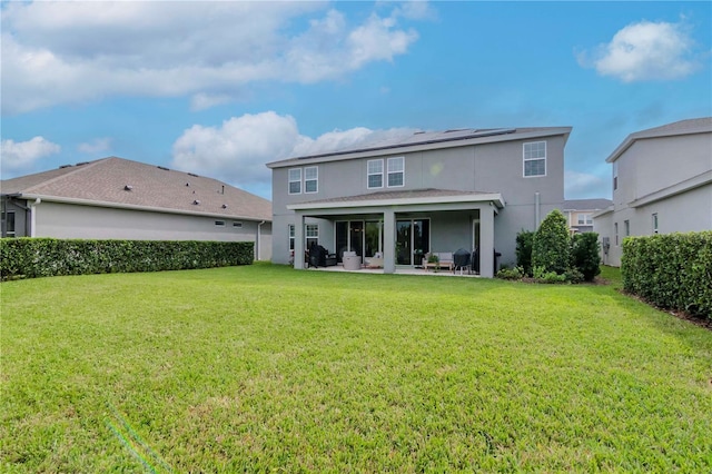 rear view of property featuring a patio area, stucco siding, and a yard