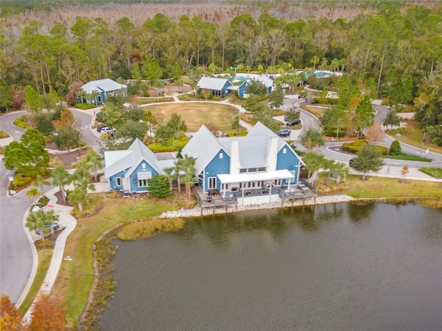 aerial view with a water view and a wooded view