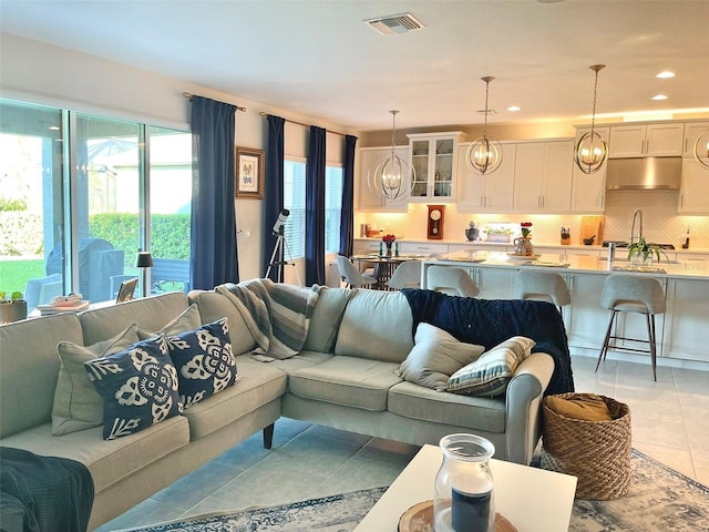 living room featuring light tile patterned flooring, visible vents, recessed lighting, and an inviting chandelier