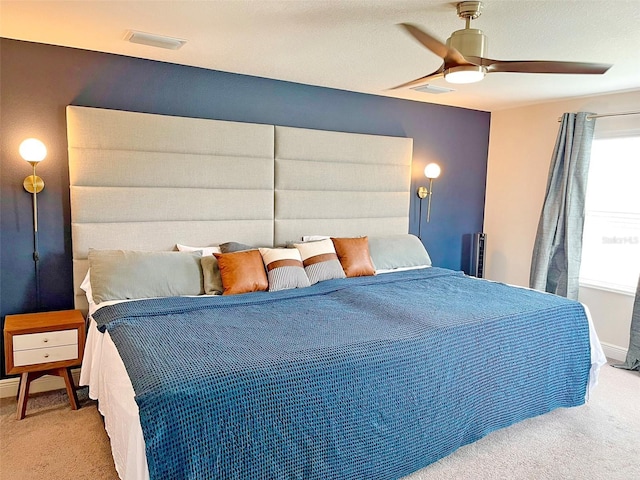 carpeted bedroom featuring baseboards, visible vents, and ceiling fan