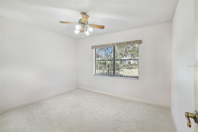 empty room featuring ceiling fan, carpet floors, and a textured ceiling