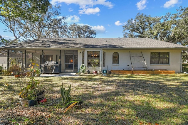 rear view of property featuring a lawn and a sunroom