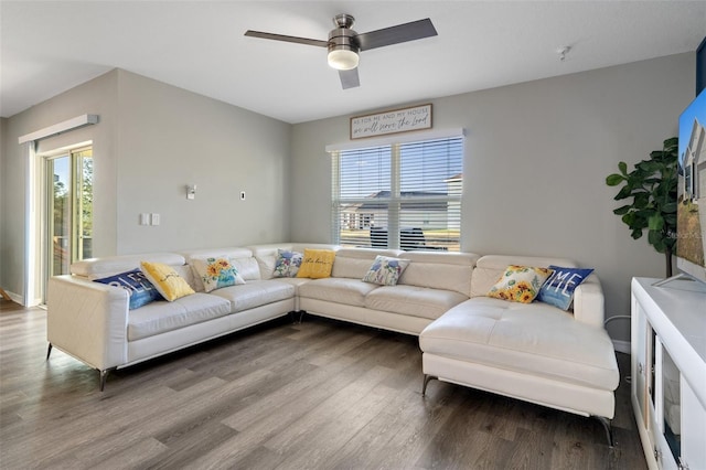 living room featuring ceiling fan, a healthy amount of sunlight, and wood-type flooring