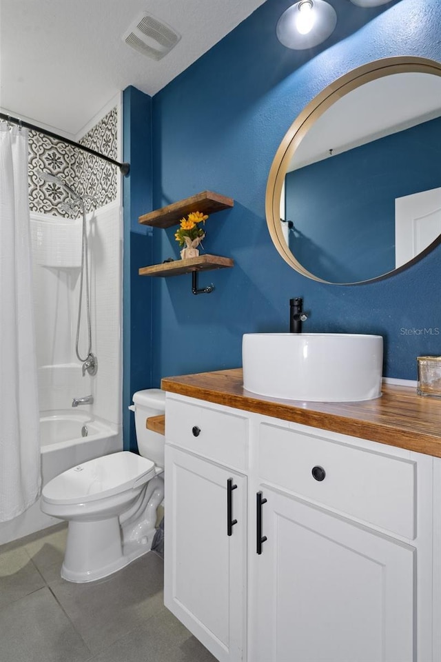 full bathroom with tile patterned floors, shower / bath combo with shower curtain, vanity, and toilet