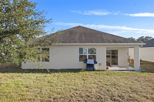 back of house featuring a lawn and a patio area