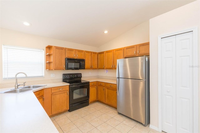 kitchen with sink, light tile patterned floors, black appliances, and vaulted ceiling