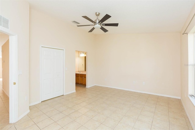 unfurnished bedroom with ensuite bath, ceiling fan, a closet, and light tile patterned floors