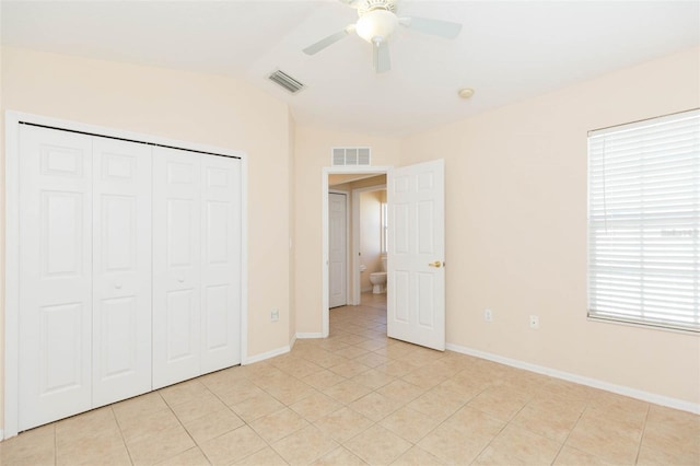 unfurnished bedroom with light tile patterned floors, a closet, ceiling fan, and lofted ceiling