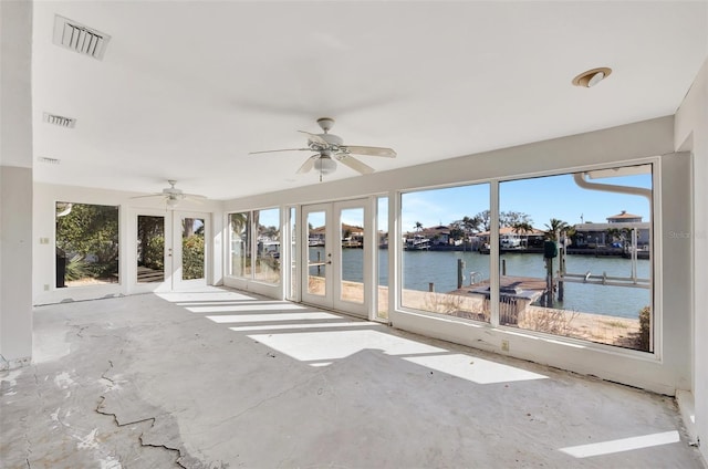 unfurnished sunroom featuring ceiling fan, french doors, and a water view