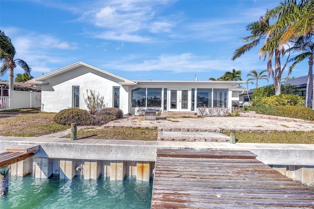 back of property with a sunroom and french doors