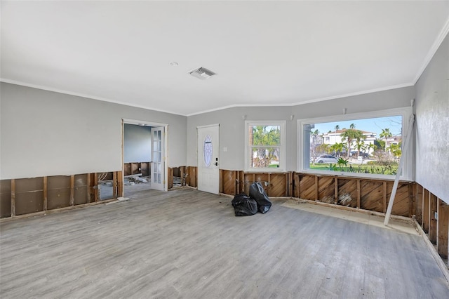 spare room featuring light wood-type flooring, wooden walls, and crown molding