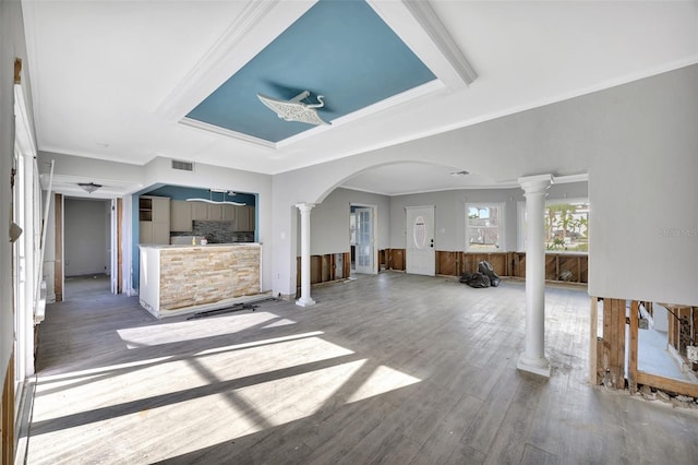 unfurnished living room with decorative columns, ornamental molding, and hardwood / wood-style flooring