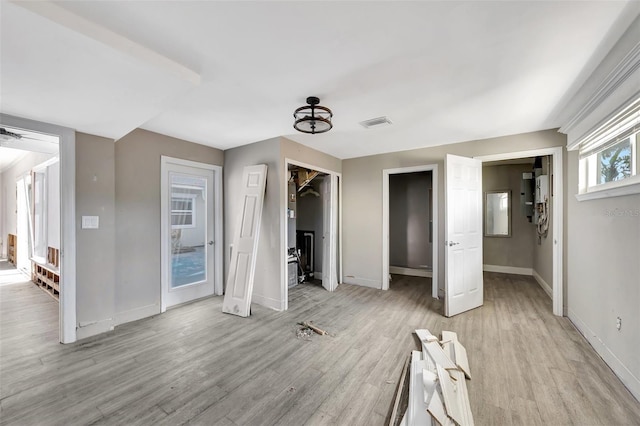 unfurnished bedroom with a closet, a spacious closet, light hardwood / wood-style flooring, and a chandelier