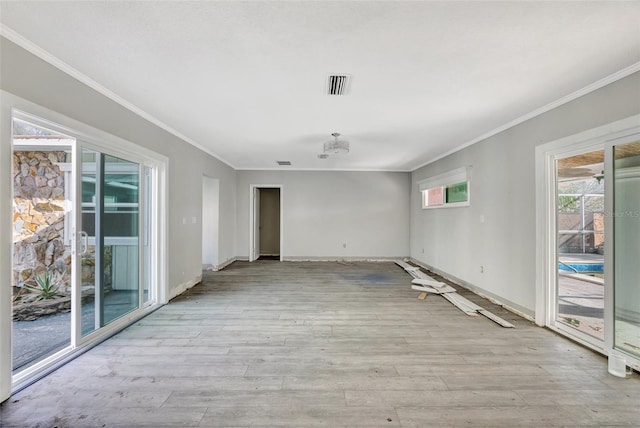 empty room featuring light hardwood / wood-style flooring and ornamental molding