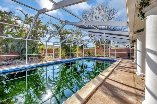 view of swimming pool featuring glass enclosure