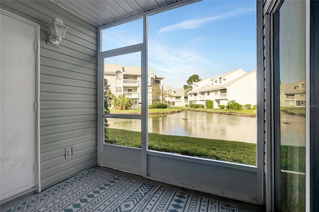 unfurnished sunroom featuring a water view