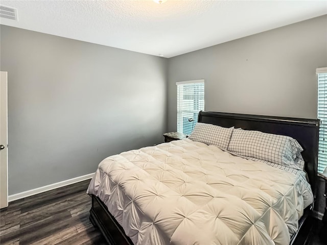 bedroom with dark wood-type flooring