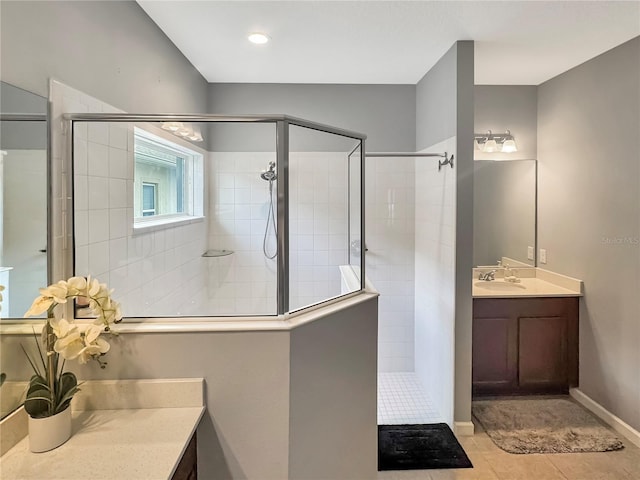 bathroom with tile patterned floors, vanity, and tiled shower