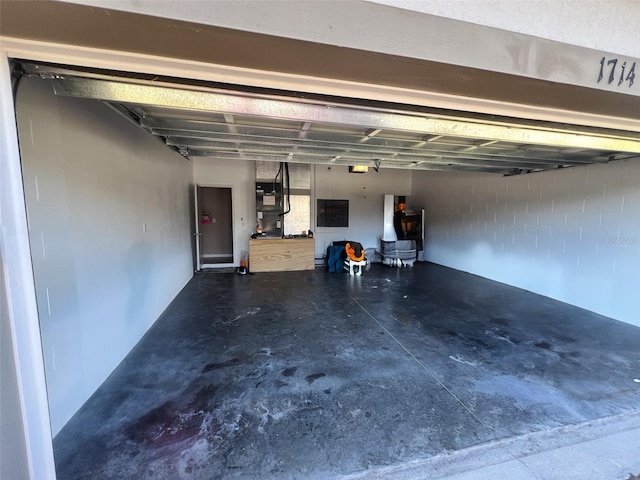 garage featuring a garage door opener and heating unit