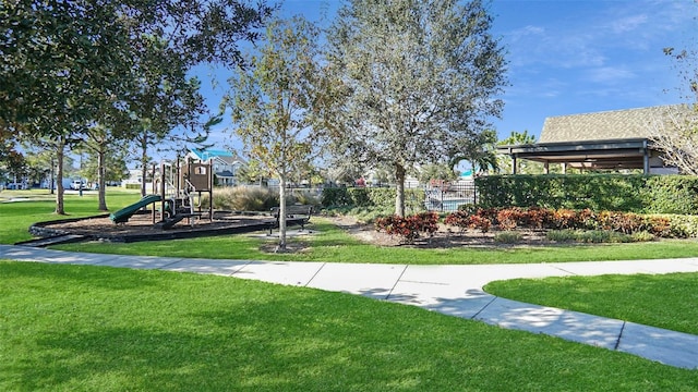 view of home's community with a playground and a yard