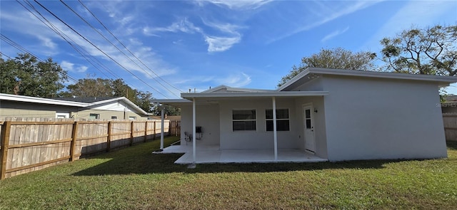 rear view of house featuring a patio area and a lawn