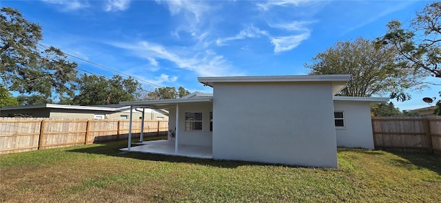 rear view of house featuring a patio area and a yard